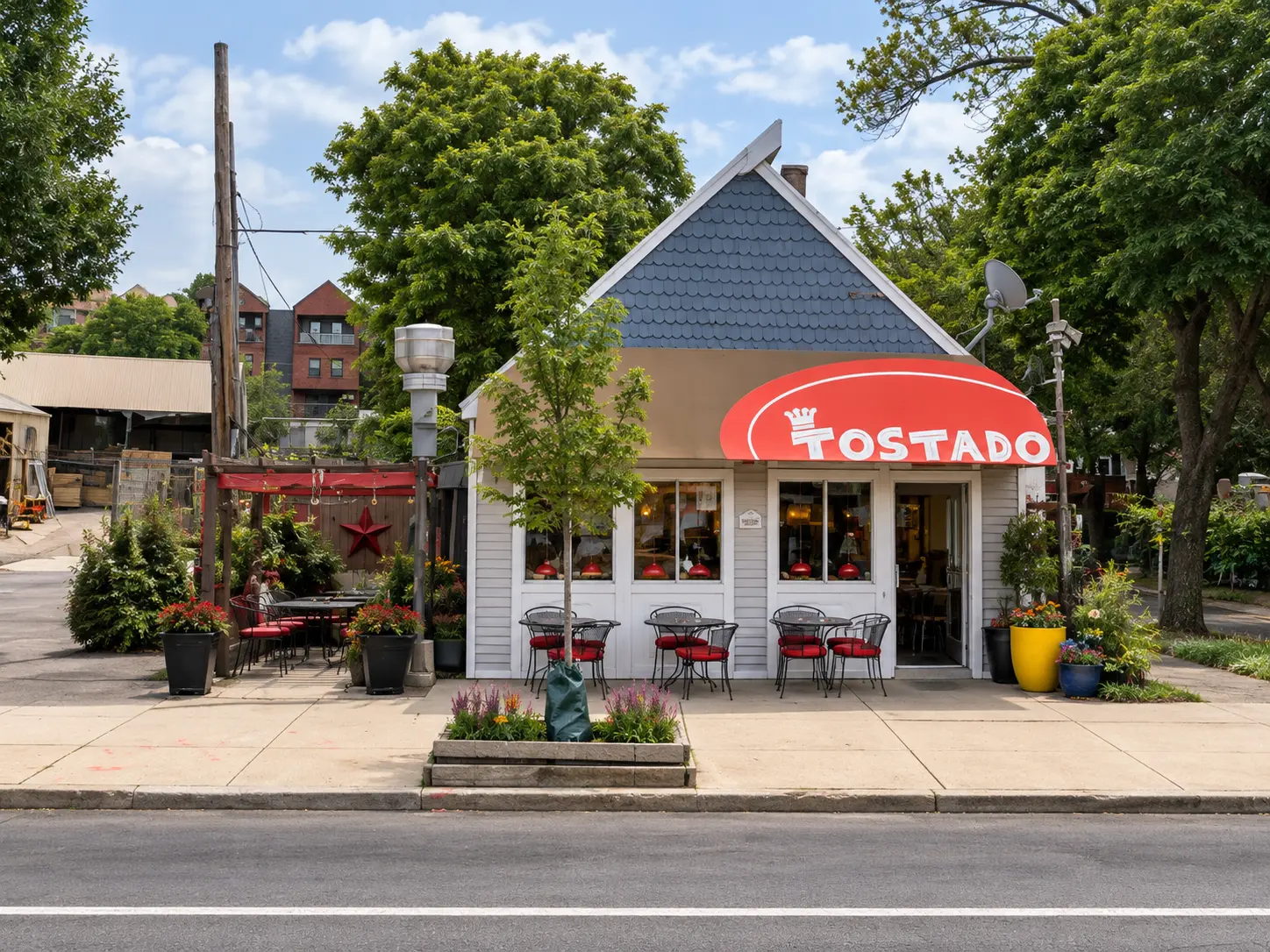 Tostado corner shop with red awning, outdoor tables and flower planters