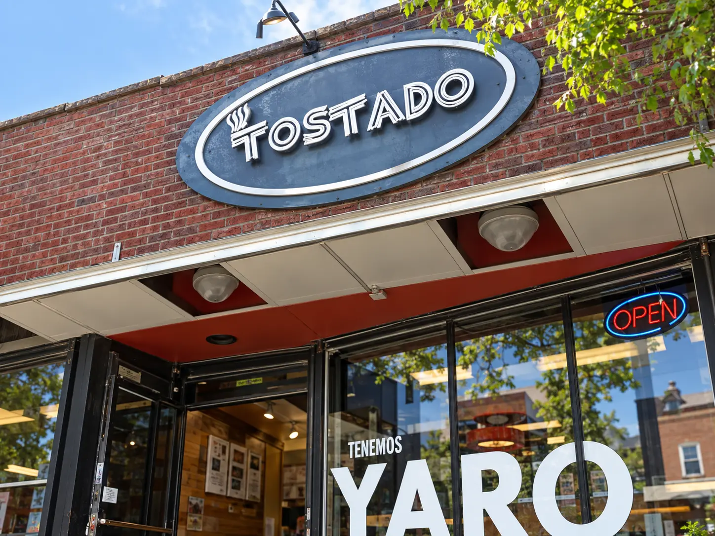 Tostado oval sign mounted on a brick storefront above the entrance