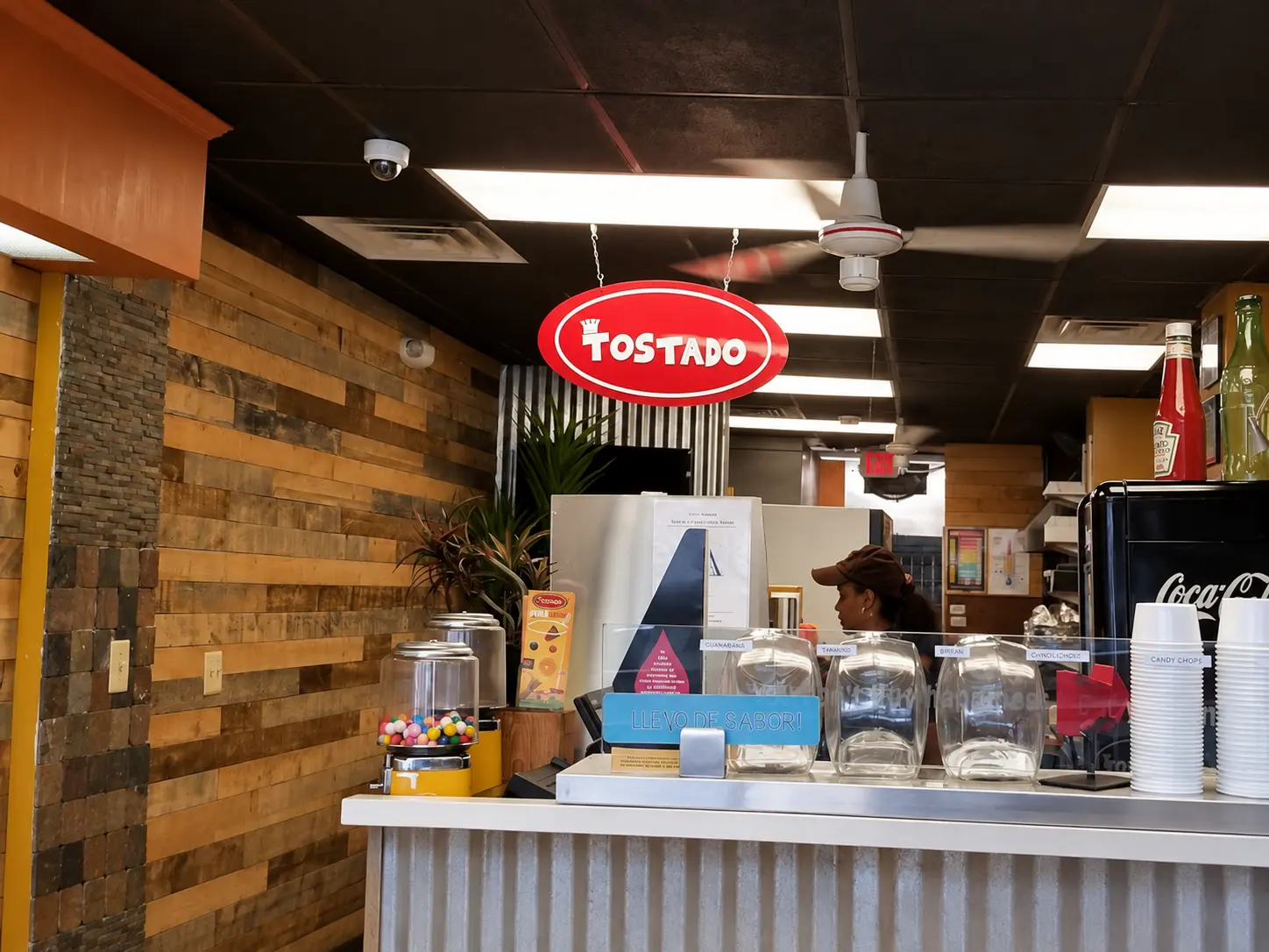 Inside Tostado, the red oval sign hanging above the service counter